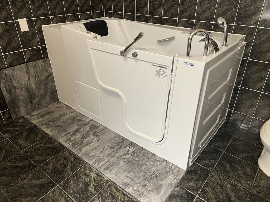 Walk-in bathtub with dark marble tile — professional installation